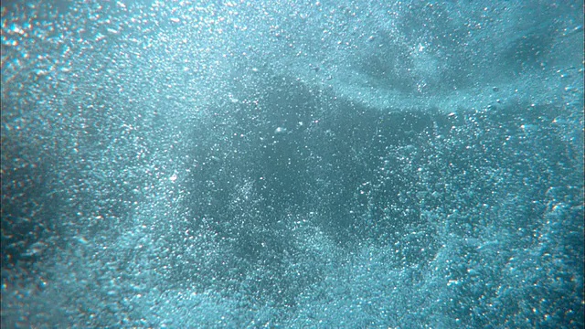 慢动作低角度女人潜水水下，阳光在背景视频下载