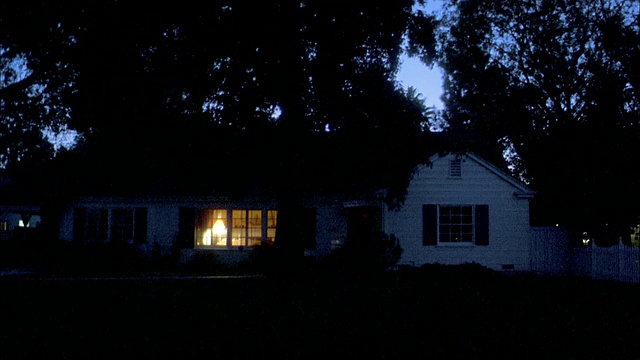 中等拍摄郊区的房子在晚上/内部灯关闭视频素材