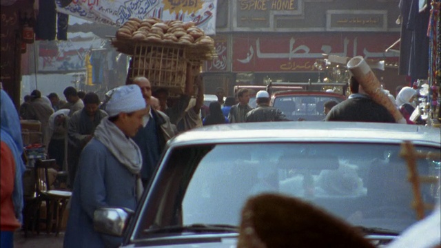 在埃及开罗的旧城区，宽阔的街道上，人们在集市上搬运货物视频下载