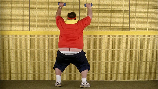 中等大小的胖男人正在举重，运动裤挂得很低视频素材