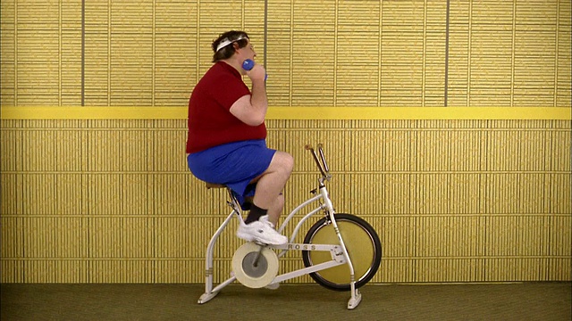 中等大小的胖子骑自行车锻炼和举重视频素材