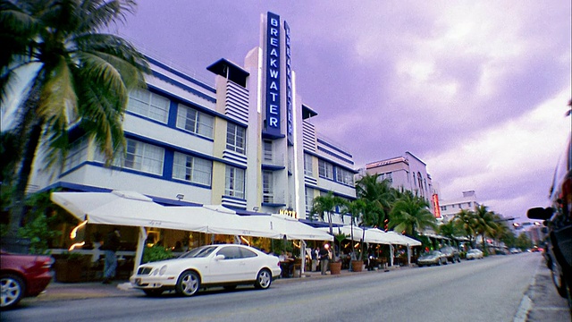 低角度广角拍摄防波堤酒店大楼w/豪华轿车驶过/迈阿密海滩，佛罗里达视频素材