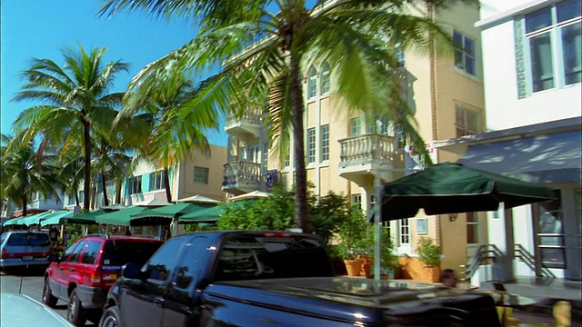 中等拍摄的汽车视角通过餐厅遮阳篷，咖啡馆和棕榈树/迈阿密海滩，佛罗里达视频素材