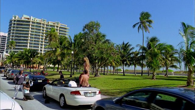 Medium shot汽车的观点通过海滩公园/照片拍摄和人在泳衣/迈阿密海滩，佛罗里达视频素材
