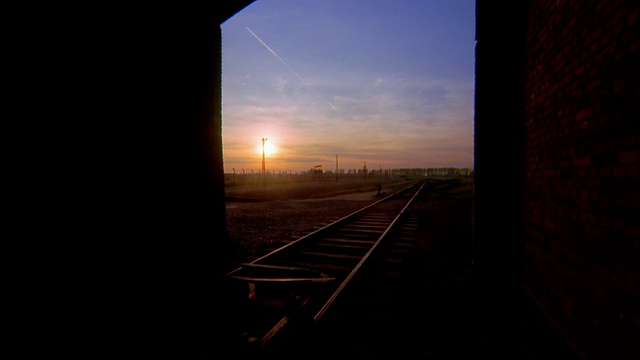 比克瑙集中营的火车轨道和隧道，夕阳背景/奥斯维辛，波兰视频下载