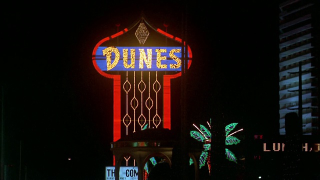 20世纪70年代，在拉斯维加斯的晚上，中等拍摄的霓虹“沙丘”赌场标志视频素材