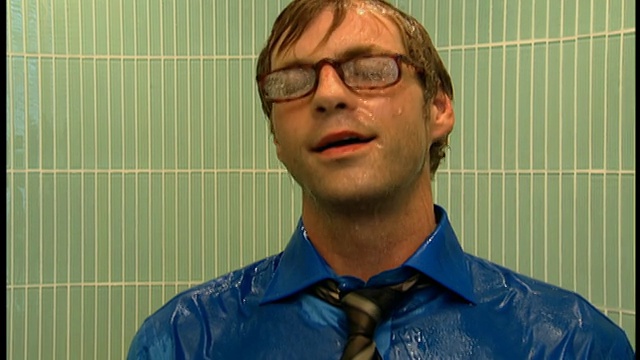 中枪男子在衬衫和领带+眼镜打开淋浴视频素材