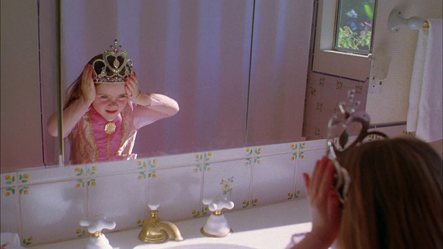 中镜头女孩穿着公主裙和皇冠在浴室镜子调整皇冠视频下载