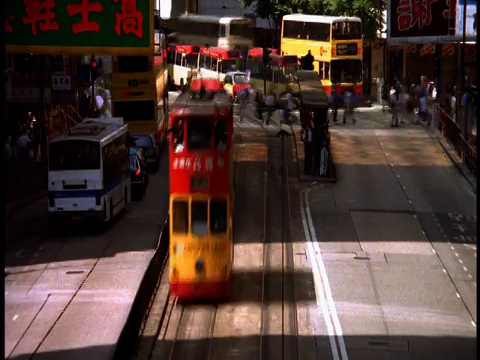 高角度广角拍摄双层巴士转向街道上的行人视频素材