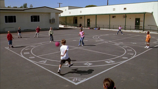 远射儿童在操场上玩踢球视频素材
