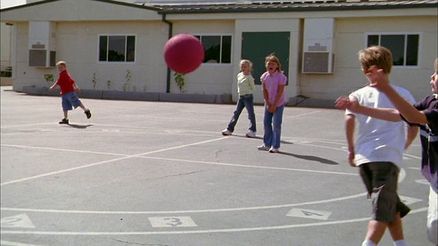 中镜头缩小男孩接球和扔在男孩跑垒在踢球游戏视频素材