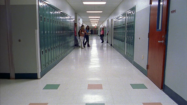 长镜头:空荡荡的走廊/学生们从教室走向走廊，交谈/进入教室视频下载