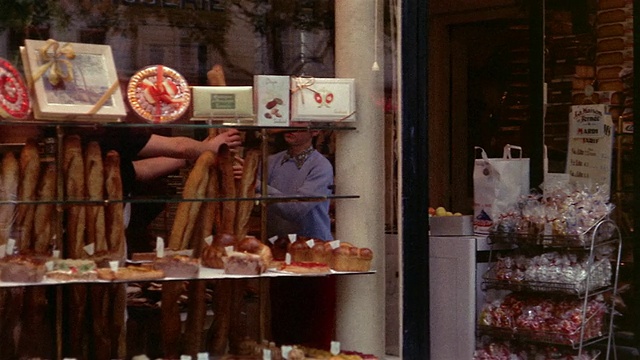 20世纪60年代，法国巴黎，一名妇女在面包房买长棍面包视频下载