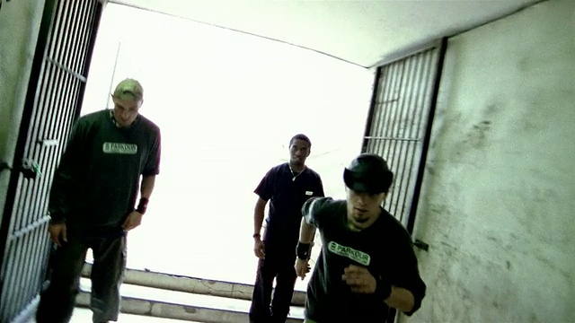 中速三名自由跑动者跑下走廊和跳墙视频下载