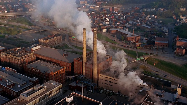 建筑物鸟瞰图和高速公路通过污染云/倾斜向下的工厂烟囱视频下载