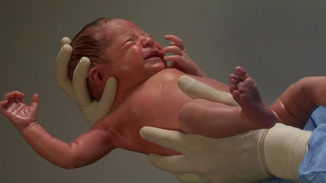 CU，戴着手套的医生手里的新生婴儿视频素材