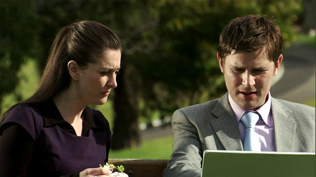 澳大利亚悉尼，两名商人在用笔记本电脑，一名妇女在吃三明治视频素材
