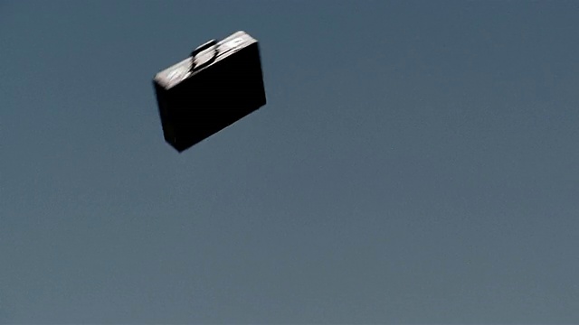 低角度公文包在空中飞行，蓝天为背景视频下载