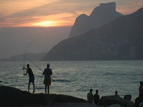 日落时分，巴西里约热内卢伊帕内玛海滩上渔民的剪影视频素材