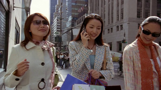 靠近走路和打电话的女人/缩小戴墨镜的女人/纽约视频素材