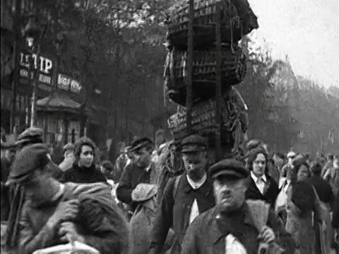 1920年，法国巴黎，人们扛着板条箱穿过繁忙的城市市场视频下载