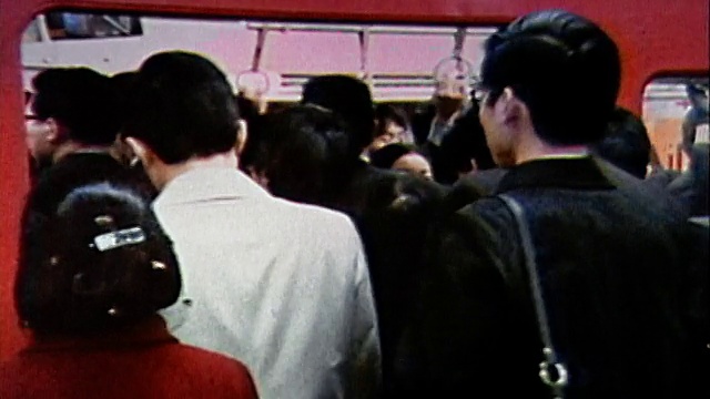 1970年，中镜头上班族在高峰时间挤上地铁/放大戴口罩以防止疾病传播的人/日本视频素材