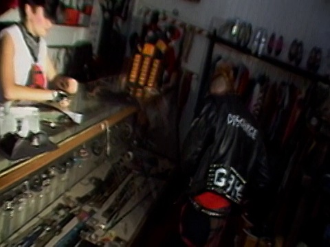 1984年，一个中等身材的朋克男孩在服装店从朋克女人那里买了带钉的皮带视频下载