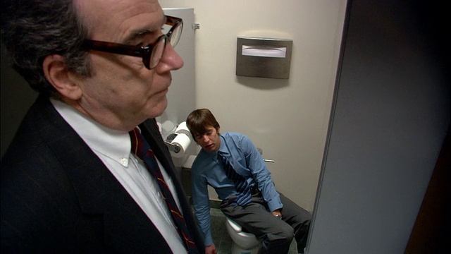 中拍老板打开浴室隔间门/男员工睡在厕所上/老板走开/低角度视频素材