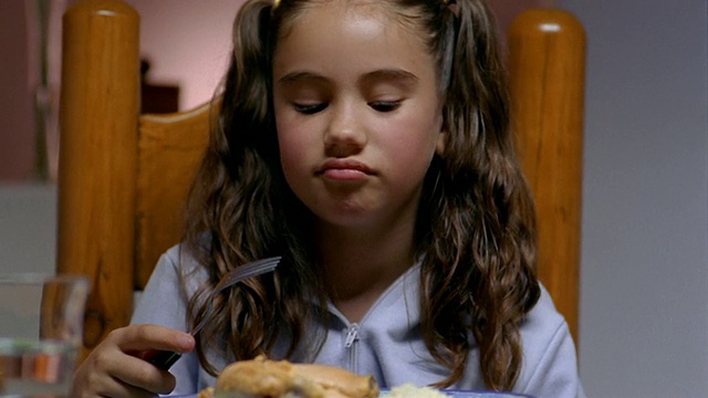 近距离女孩用叉子挑食物，在用餐时皱眉/墨西哥城视频下载