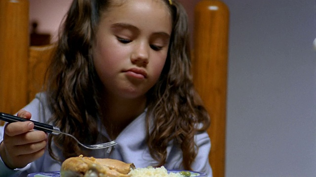 近镜头拍摄男孩玩食物，女孩采摘食物和皱眉在用餐/墨西哥城视频素材