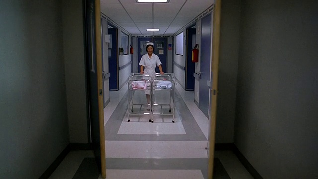 在墨西哥城的婴儿床里，医院走廊的门打开，护士正在推着双胞胎的婴儿视频素材