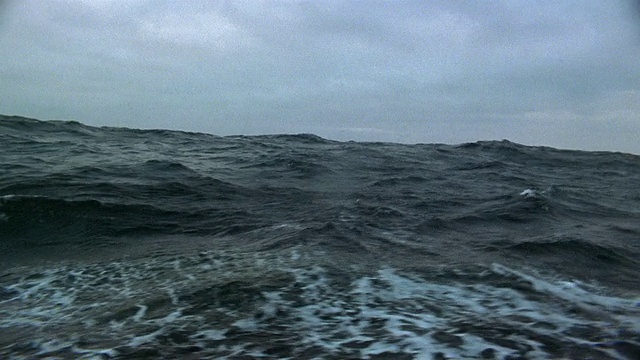中等拍摄的船的观点航行在波涛汹涌的海面上阴天/北极视频素材