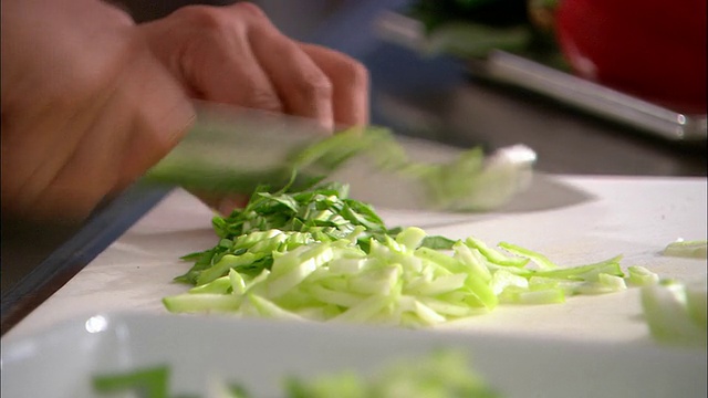 在新西兰奥克兰，小白菜被切在砧板上/架子上被抬到盘子上视频素材