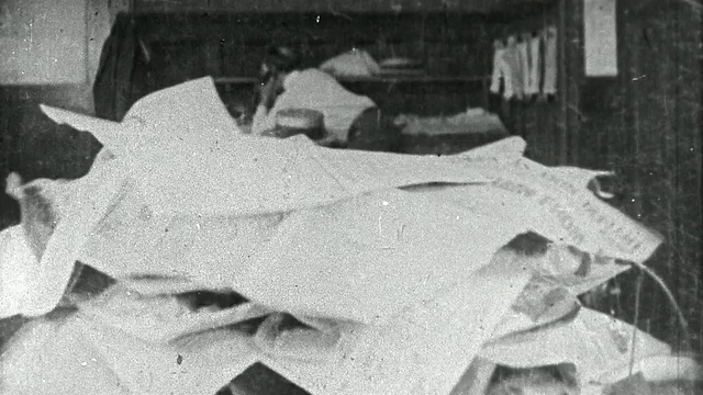 1921年，黑白中镜头压力巨大的男人(埃迪·莱昂斯饰)从桌子上的一堆文件中走出来/《和平与安宁》视频下载