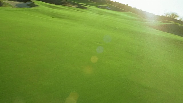 空中飞过黑钻牧场高尔夫球场的球道，经过球童和高尔夫球手视频素材