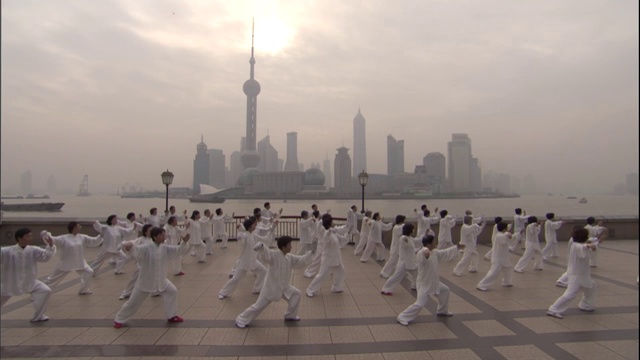 HA WS PAN穿着白色制服的男人和女人在海滨练习太极/中国视频下载
