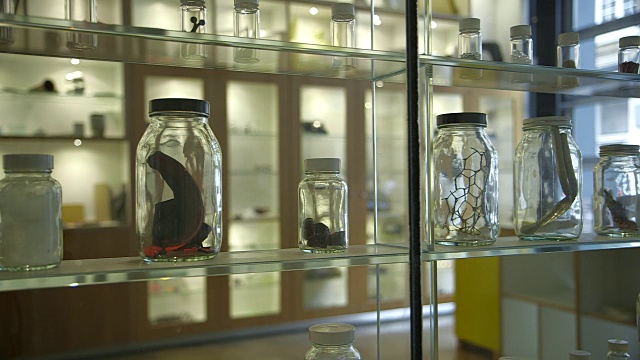 英国，展示箱内装有各种材料的小玻璃瓶，展示箱内反射出微弱的阴影。视频下载