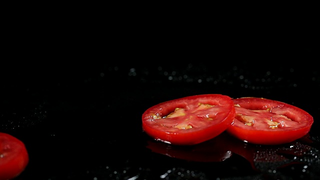 SLO MO西红柿薄片落在潮湿的表面视频下载