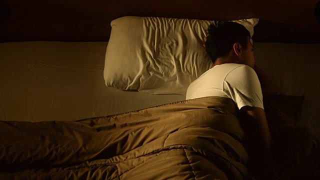 一名沮丧的男子因失眠躺在床上的画面视频下载