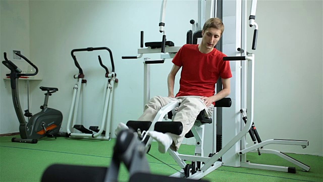 这个年轻人正在模拟器上锻炼肌肉。视频素材