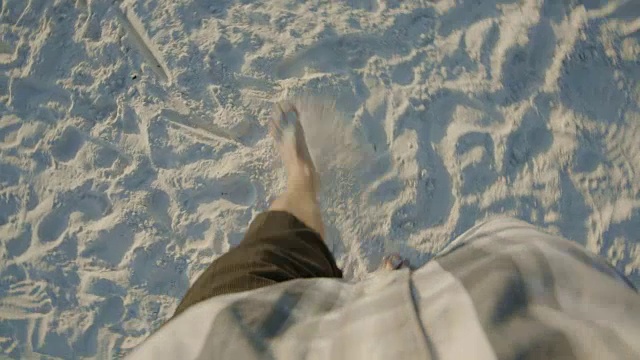 男人往下看，走在沙滩上看日落视频素材