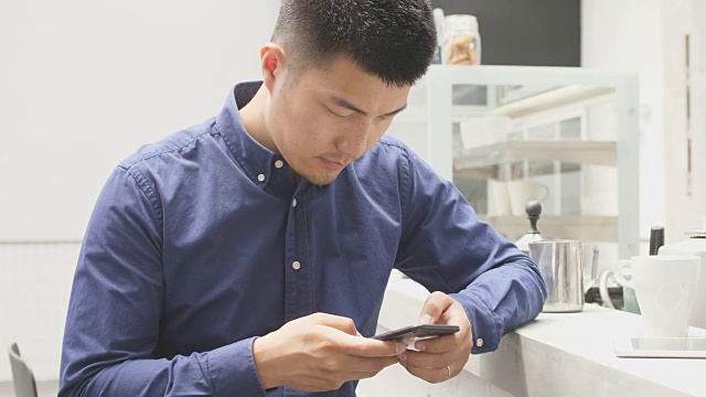 年轻的亚洲男子使用手机视频素材