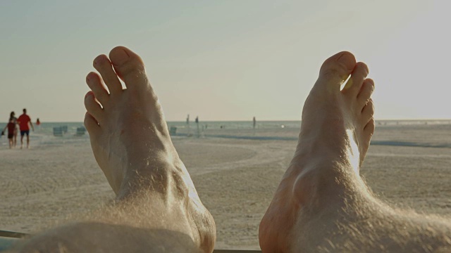 男人脚的观点放松日落佛罗里达海滩夏天视频素材