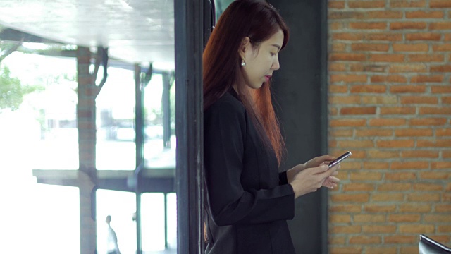 商业女性使用和触摸智能手机在办公室工作视频下载