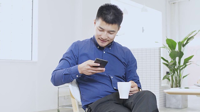 年轻的亚洲男子使用手机视频素材