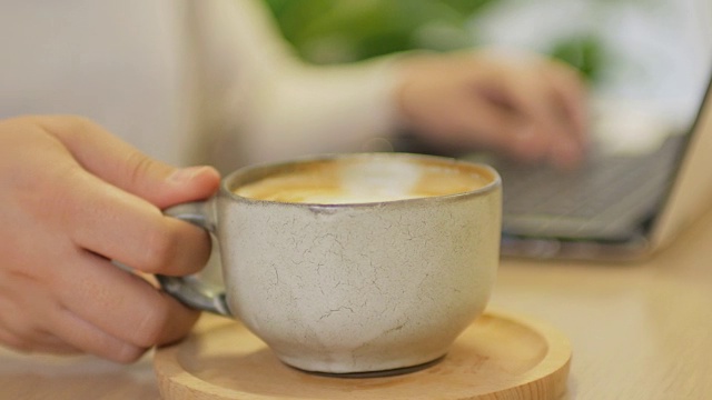 用笔记本电脑和咖啡在咖啡馆休息时间工作的女人视频下载