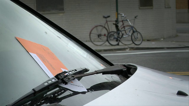 一名男子从汽车挡风玻璃雨刷下取出停车罚单/美国纽约视频下载