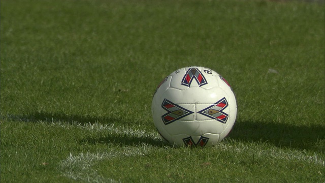 CU足球运动员将球放在场地上，然后踢球并追着球跑/谢菲尔德，英格兰，英国视频素材