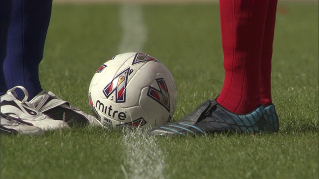 中大足球运动员站在球场附近，然后把球踢到周围/谢菲尔德，英格兰，英国视频素材