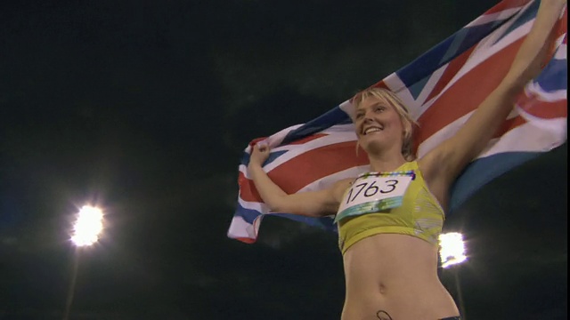 在英国谢菲尔德赢得田径比赛后，LA MS Woman举着英国国旗视频下载